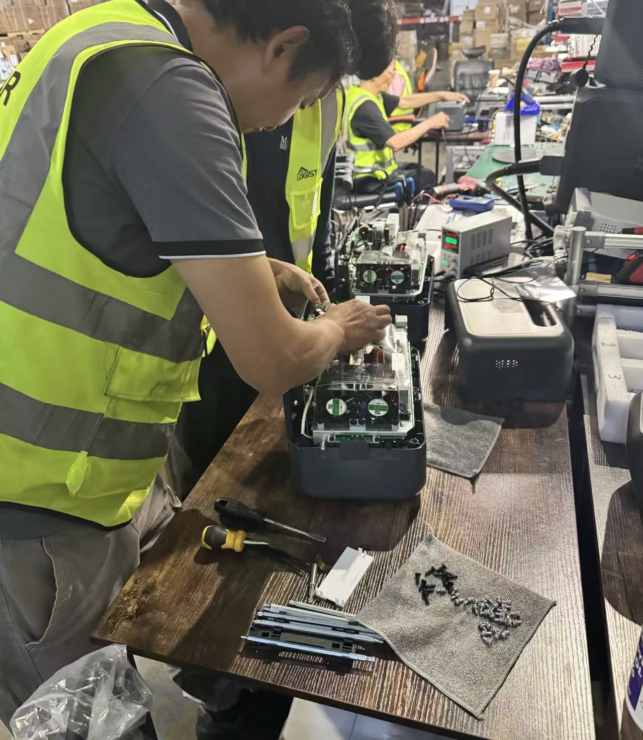 Technicians repairing returned power stations at the bench