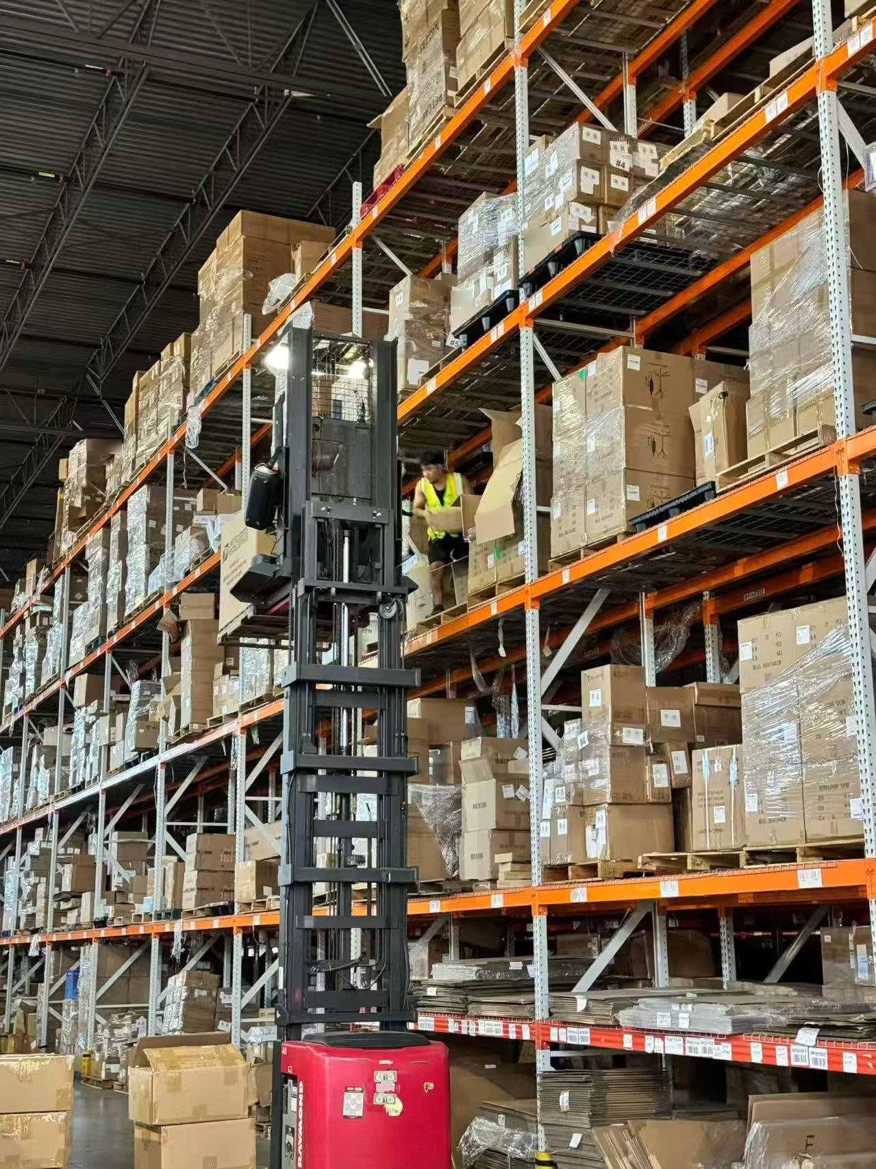 A team member picking cartons from the upper rack